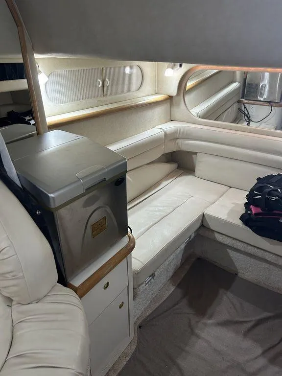 Slide: The Image of Interior of 1997 Sea Ray 330 Sundancer with white leather seating and compact fridge. - 32