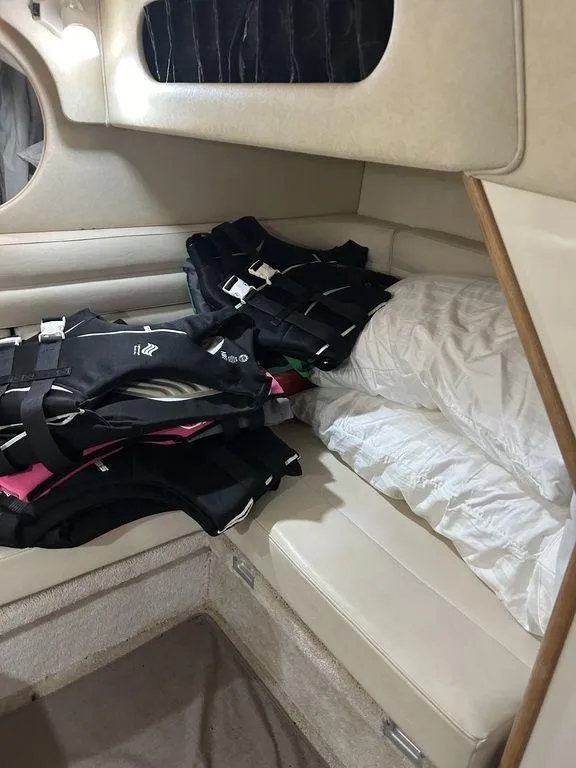 Slide: The Image of 1997 Sea Ray 330 Sundancer cabin with life jackets on bed. - 36