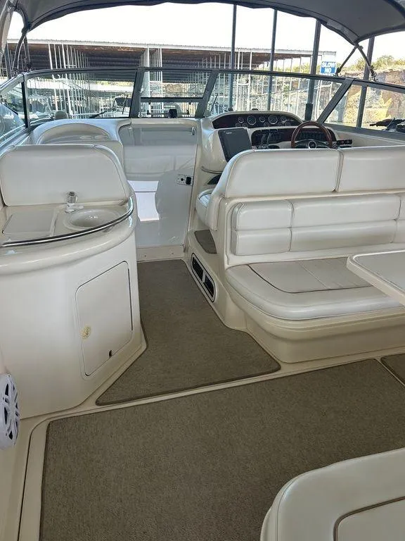 Slide: The Image of 1997 Sea Ray 330 Sundancer interior with helm, seating, and sink. - 7