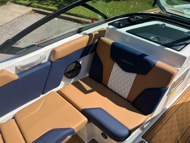 Slide: The Image of 2023 MasterCraft XT24 boat interior with tan and navy seating. - 4