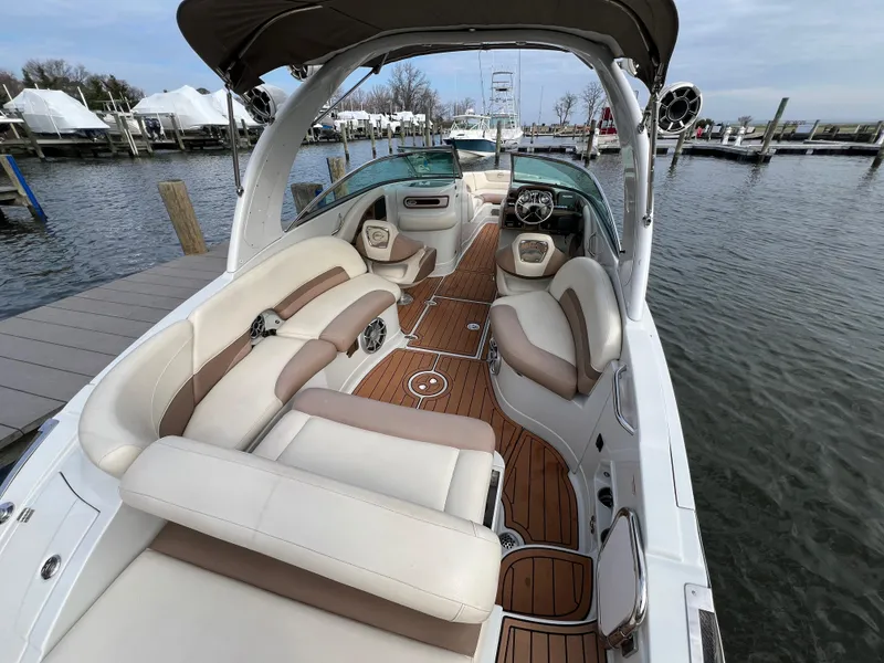 Slide: The Image of 2016 Crownline 270 SS boat interior with luxurious seating and wood flooring at a marina. - 1