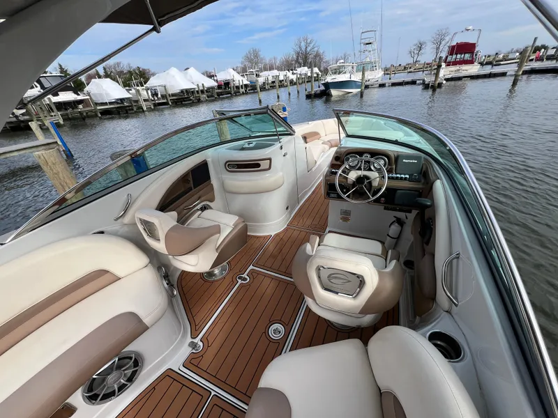 Slide: The Image of 2016 Crownline 270 SS boat interior with luxurious seating and modern dashboard at a marina. - 12