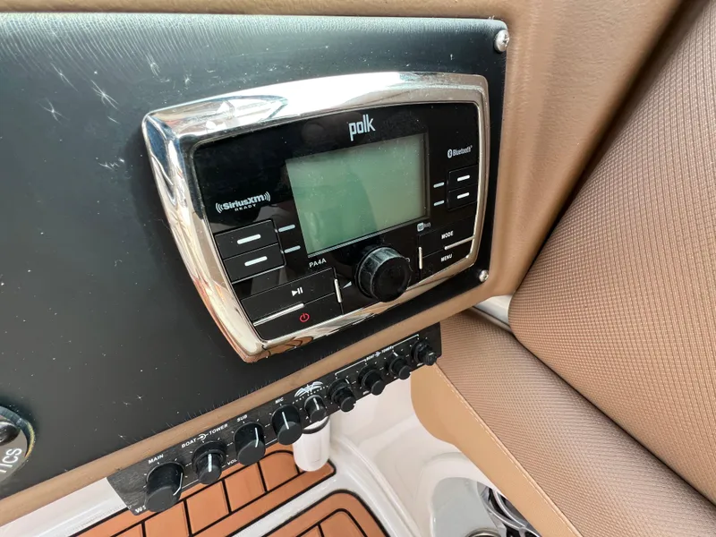 Slide: The Image of Polk audio system on 2016 Crownline 270 SS boat dashboard with SiriusXM and Bluetooth features. - 16