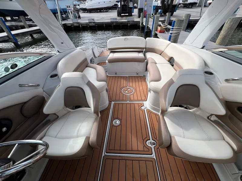 Slide: The Image of 2016 Crownline 270 SS boat interior with luxurious seating and teak-style flooring at a marina. - 20