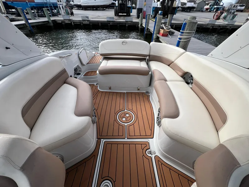 Slide: The Image of 2016 Crownline 270 SS boat interior with beige seating and teak-style flooring at a marina. - 23