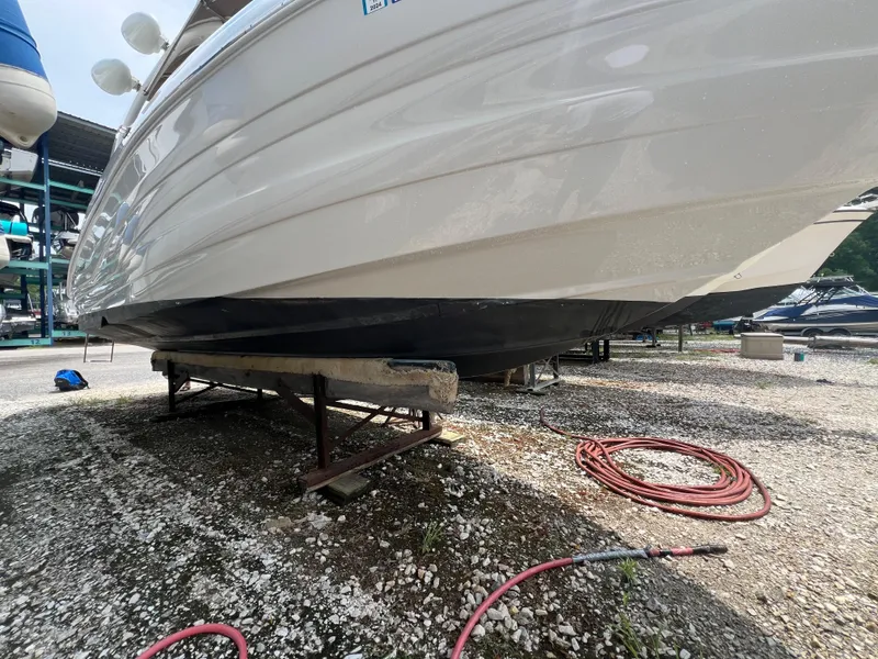 Slide: The Image of 2016 Crownline 270 SS boat on dry dock, side view, with hoses nearby. - 28