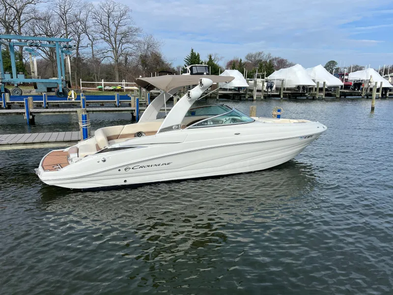 Slide: The Image of 2016 Crownline 270 SS boat docked in a marina, calm water, clear sky. - 4