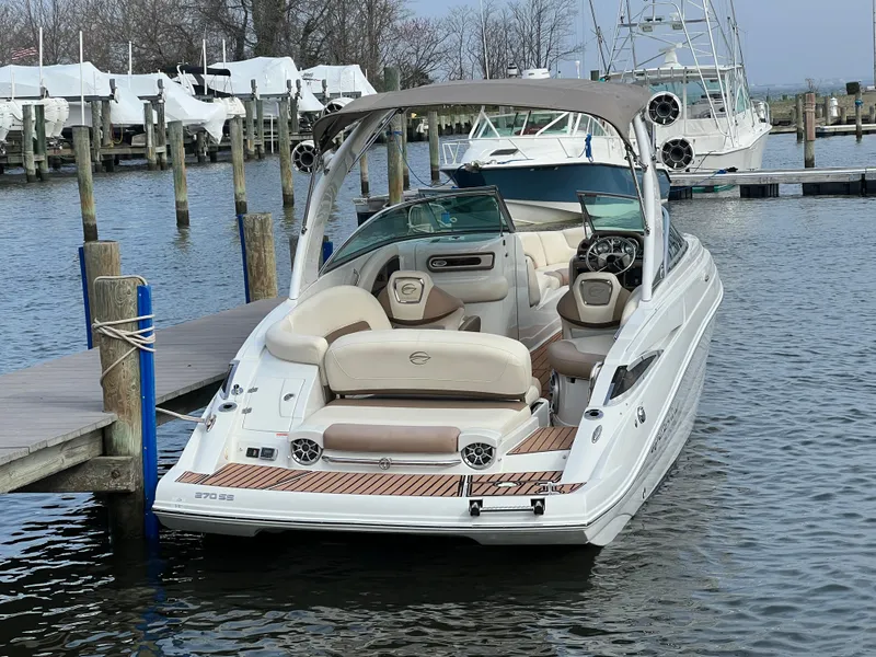 Slide: The Image of 2016 Crownline 270 SS boat docked at marina, featuring spacious seating and sleek design. - 6