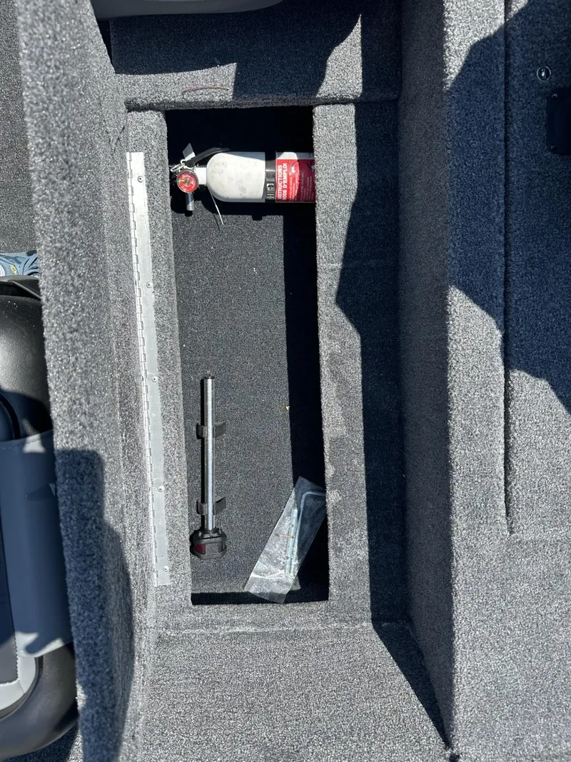 Slide: The Image of 2023 Tracker Pro 170 storage compartment with fire extinguisher and tools. - 15