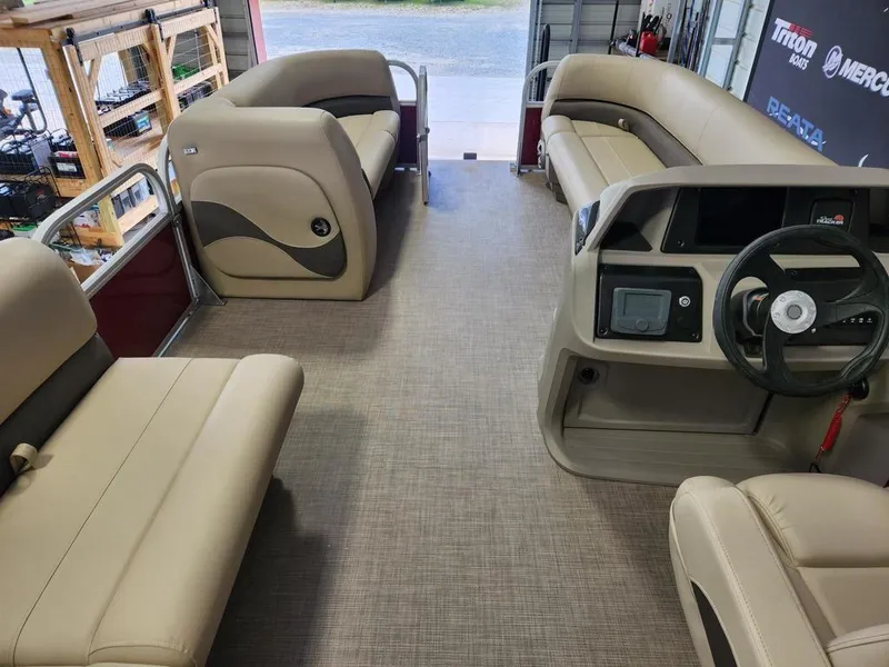 Slide: The Image of 2025 Sun Tracker PARTY BARGE® 18 DLX interior with beige seating and steering console. - 12