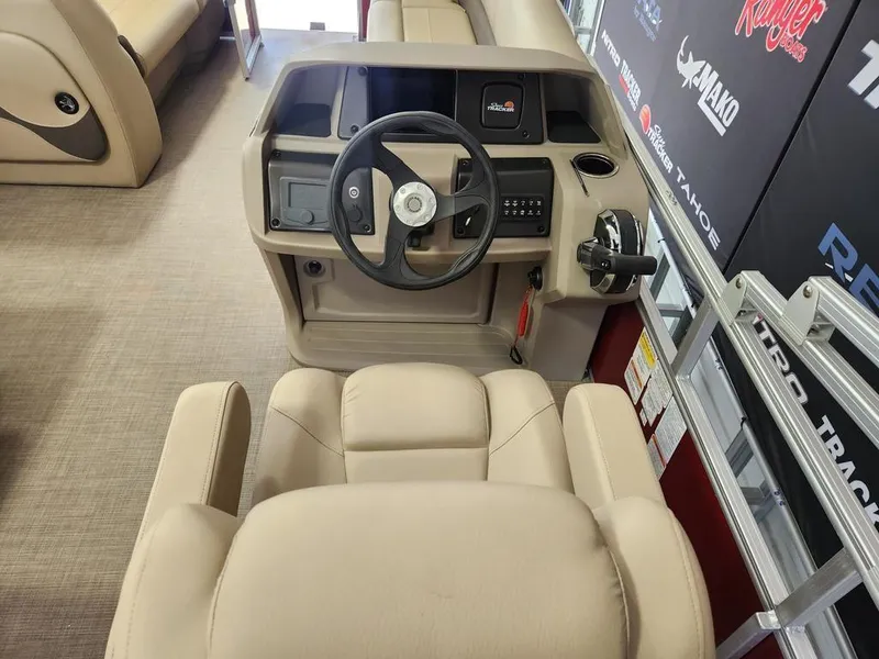 Slide: The Image of 2025 Sun Tracker PARTY BARGE® 18 DLX helm with beige seating and steering console. - 13