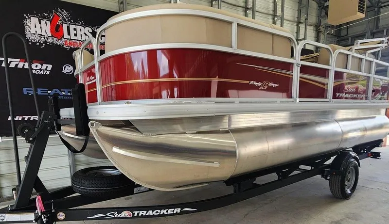 Slide: The Image of 2025 Sun Tracker PARTY BARGE® 18 DLX pontoon boat on trailer in showroom. - 8
