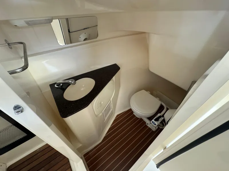 Slide: The Image of 2014 Scout 275 Dorado boat bathroom with sink, toilet, and wooden floor. - 27