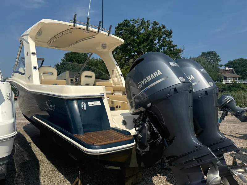 Slide: The Image of 2014 Scout 275 Dorado boat with twin Yamaha engines, parked outdoors. - 3