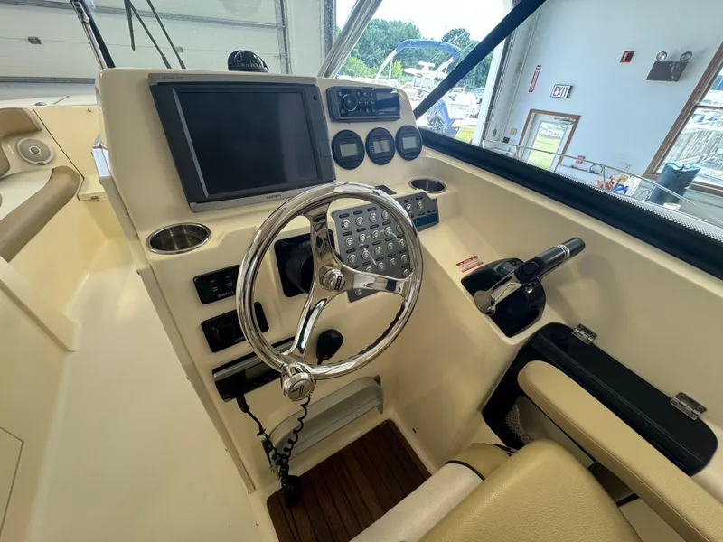 Slide: The Image of 2014 Scout 275 Dorado boat helm with steering wheel and control panel. - 31