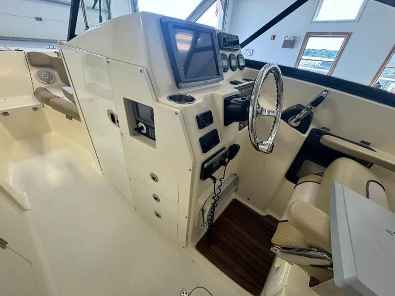 Slide: The Image of 2014 Scout 275 Dorado boat helm with steering wheel and navigation system. - 32