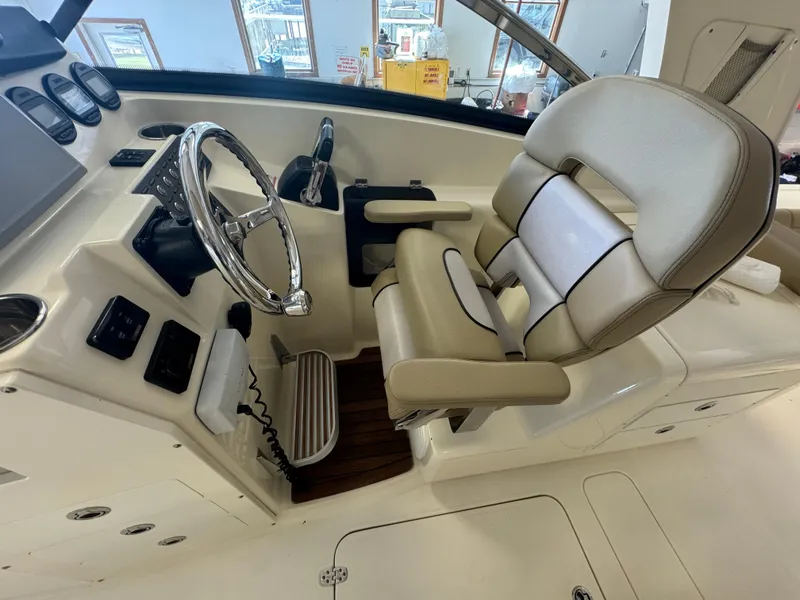 Slide: The Image of 2014 Scout 275 Dorado boat helm with steering wheel and captain's chair. - 33
