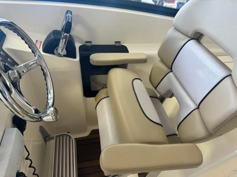 Slide: The Image of 2014 Scout 275 Dorado boat interior with steering wheel and cushioned seats. - 34