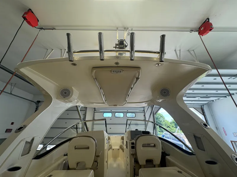 Slide: The Image of 2014 Scout 275 Dorado boat interior with dual seats and overhead rod holders. - 45