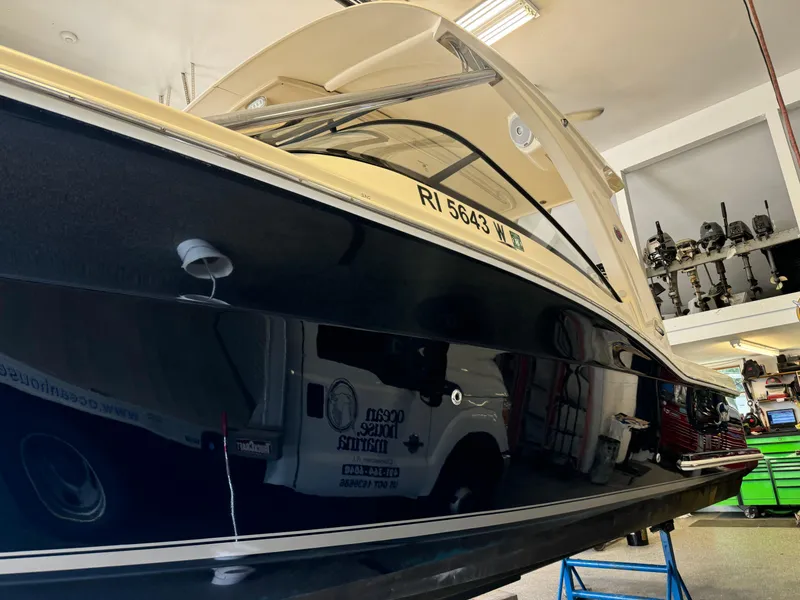 Slide: The Image of 2014 Scout 275 Dorado boat in a garage, side view with registration number RI 5643. - 8