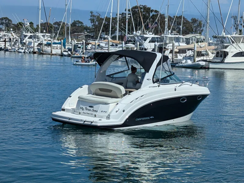 Slide: The Image of 2011 Chaparral Signature 270 boat cruising in a marina with other boats docked. - 19