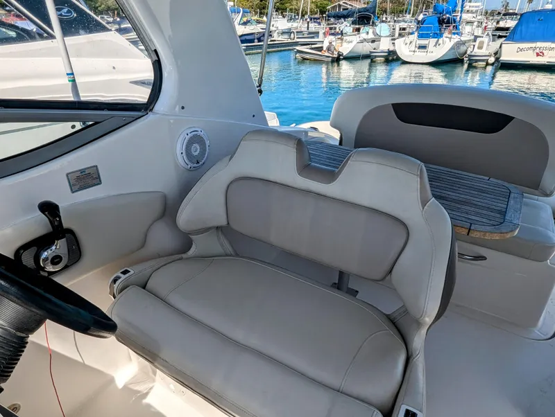 Slide: The Image of 2011 Chaparral Signature 270 boat interior with helm seat and marina background. - 28