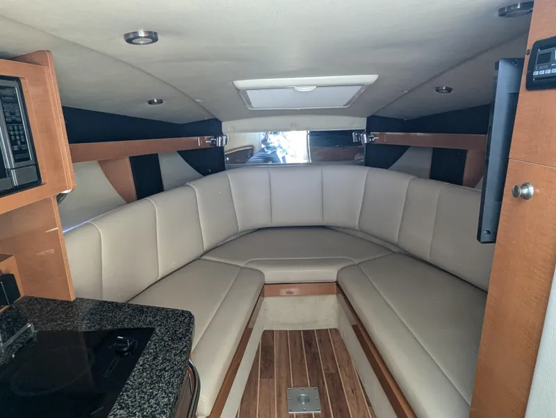Slide: The Image of 2011 Chaparral Signature 270 cabin interior with beige seating and wooden flooring. - 30