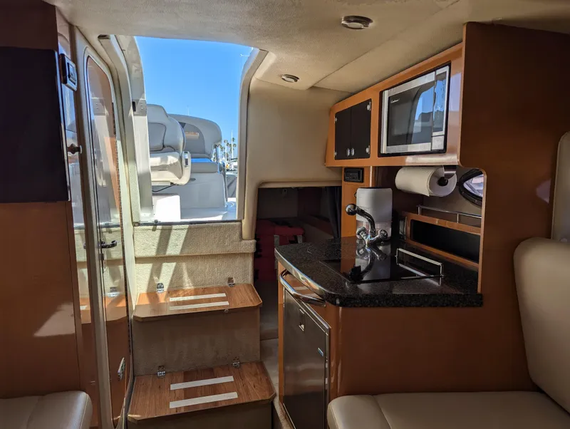 Slide: The Image of Interior of 2011 Chaparral Signature 270 boat with kitchenette and stairs to deck. - 31