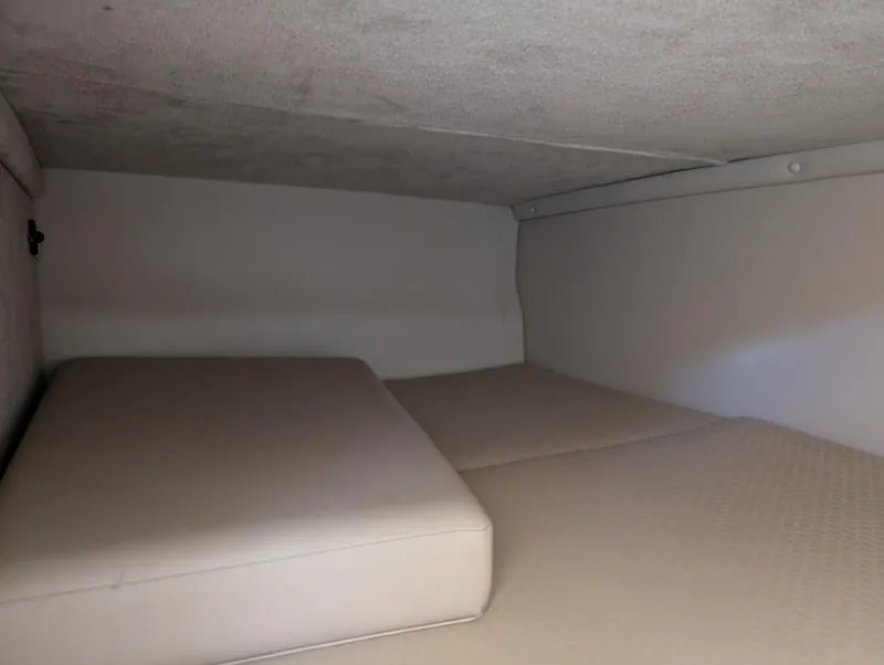 Slide: The Image of Interior cabin of 2011 Chaparral Signature 270 boat with cushioned sleeping area. - 37