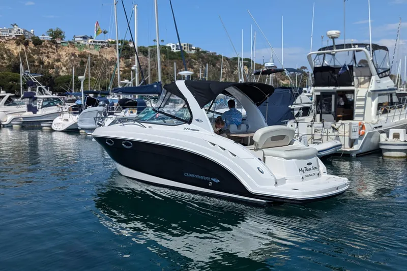 Slide: The Image of 2011 Chaparral Signature 270 boat docked in a marina, surrounded by other vessels. - 43