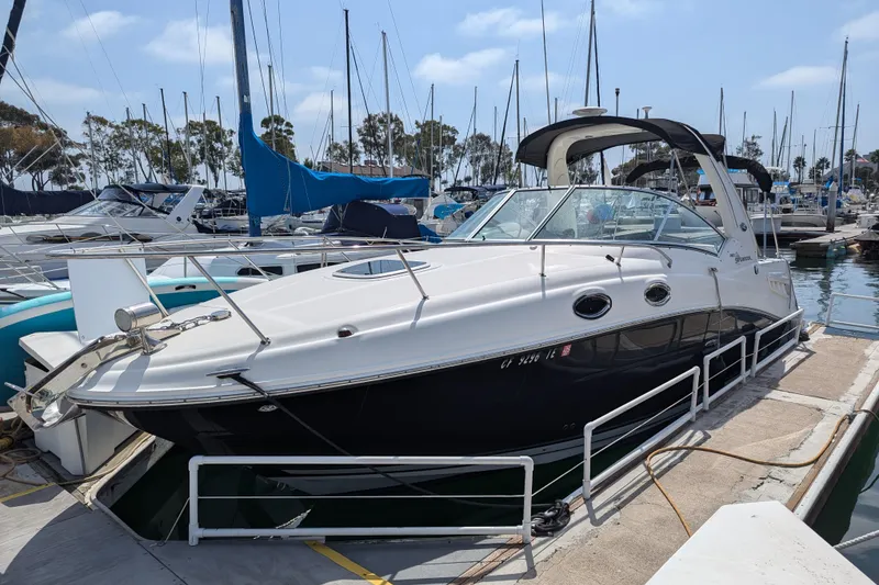 Slide: The Image of 2011 Chaparral Signature 270 boat docked in a marina, surrounded by other vessels. - 44