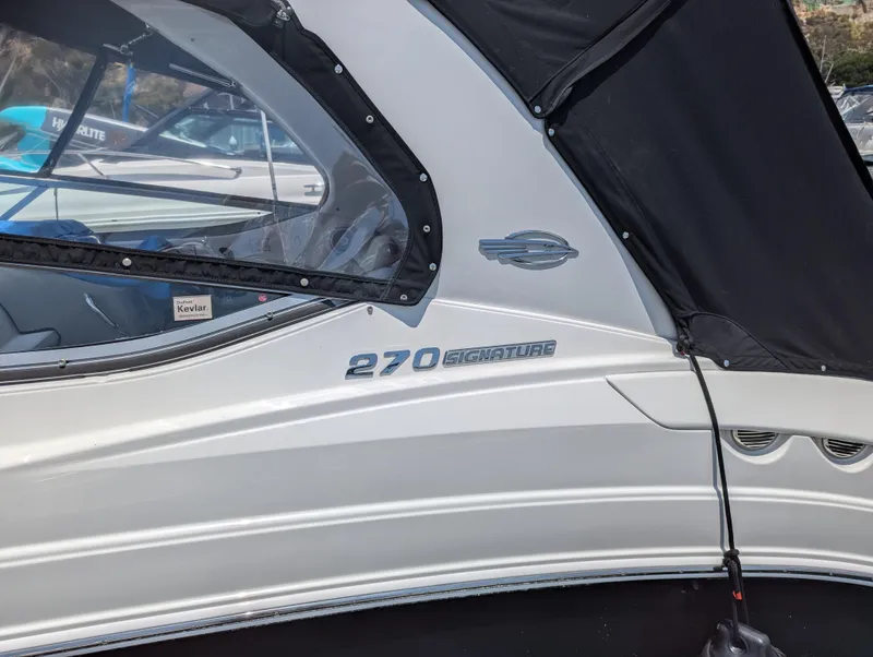 Slide: The Image of 2011 Chaparral Signature 270 boat side view with logo and black canopy. - 46
