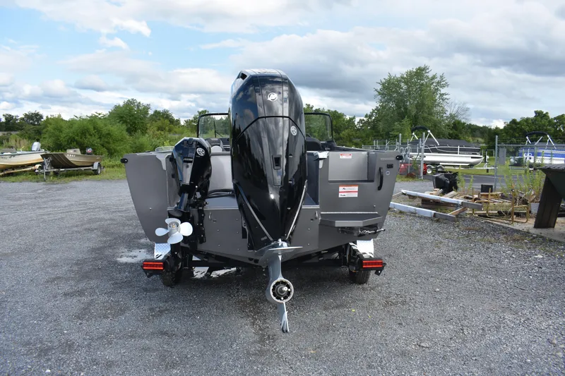 Slide: The Image of 2023 Crestliner 2250 Authority boat, rear view, parked on gravel lot. - 2