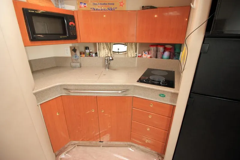 Slide: The Image of Compact kitchen area in a 2001 Formula 41 PC boat with microwave and stovetop. - 23