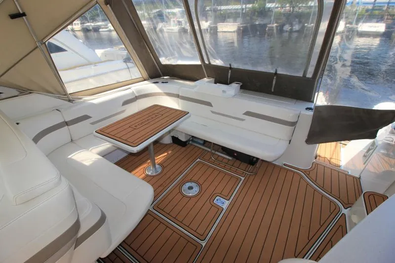 Slide: The Image of 2001 Formula 41 PC boat interior with seating and table, docked by the water. - 9