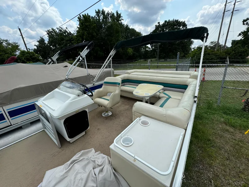 Slide: The Image of 1995 AquaPatio 240 pontoon boat with seating, canopy, and console, parked outdoors. - 3