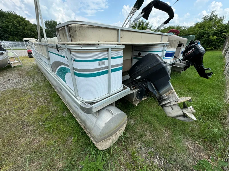 Slide: The Image of AquaPatio 240 pontoon boat, 1995 model, parked on grass with visible outboard motor. - 4