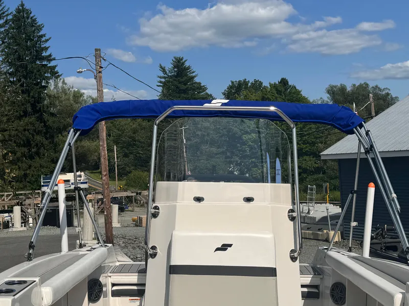 Slide: The Image of 2024 Starcraft SVX 191 OB CC boat with blue canopy in outdoor setting. - 9