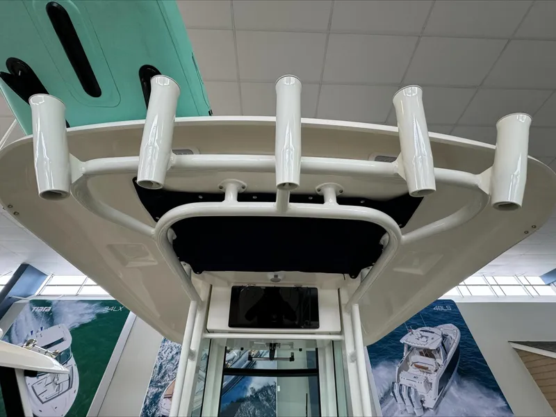 Slide: The Image of 2025 Boston Whaler 250 Outrage boat with rod holders, displayed indoors. - 12