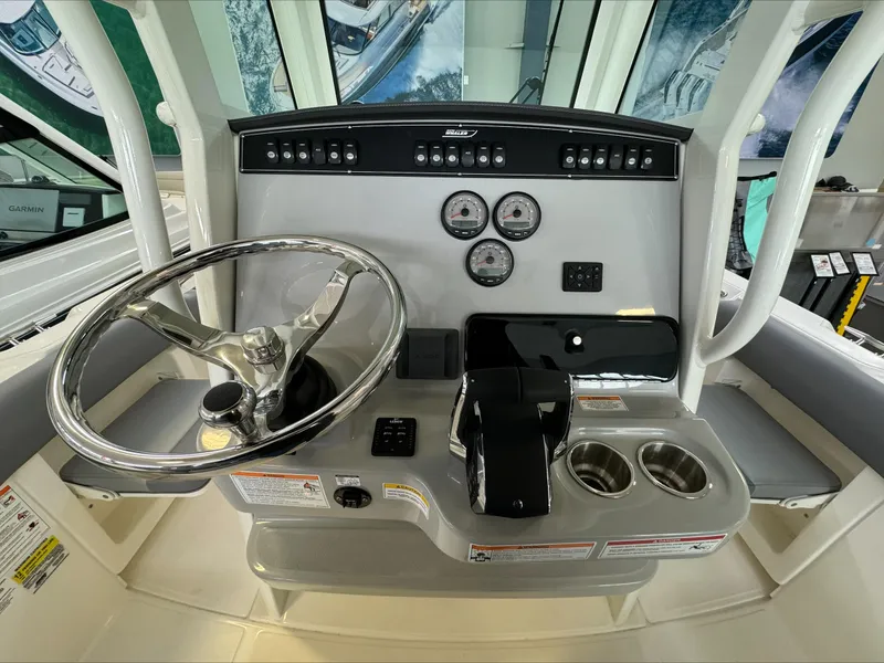 Slide: The Image of 2025 Boston Whaler 250 Outrage helm with steering wheel, gauges, and controls. - 15