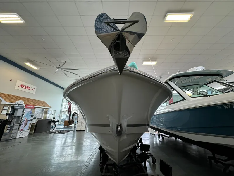 Slide: The Image of 2025 Boston Whaler 250 Outrage boat displayed indoors, showcasing its sleek bow design. - 26