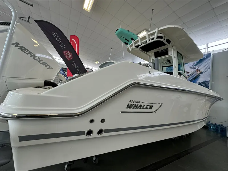 Slide: The Image of 2025 Boston Whaler 250 Outrage boat displayed indoors, showcasing sleek design and modern features. - 3