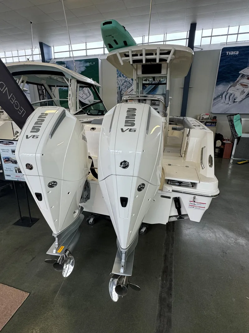 Slide: The Image of 2025 Boston Whaler 250 Outrage with dual outboard engines in showroom. - 4