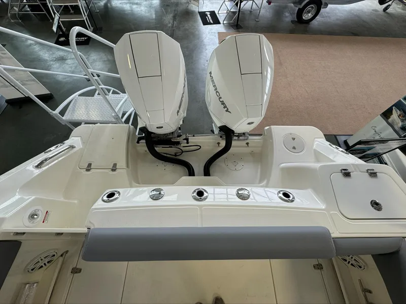 Slide: The Image of 2025 Boston Whaler 250 Outrage with dual Mercury outboard engines in showroom. - 6