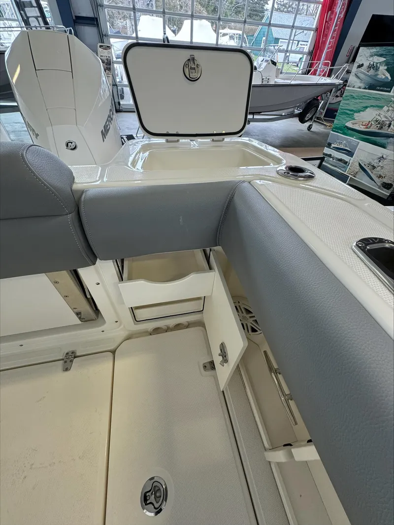 Slide: The Image of 2025 Boston Whaler 250 Outrage interior with open storage compartments and seating. - 8
