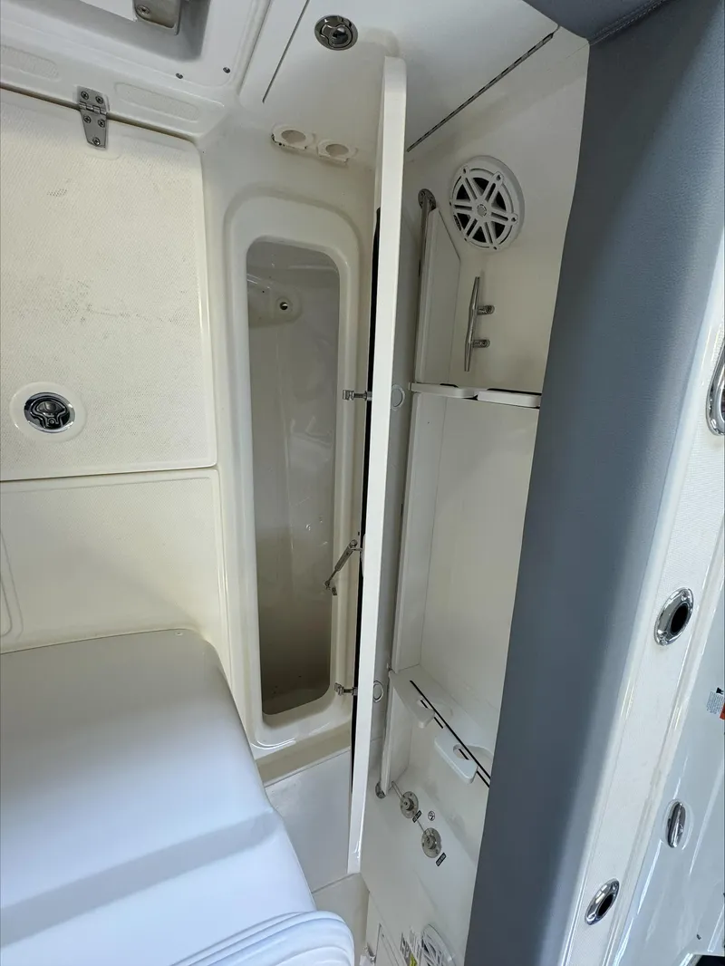 Slide: The Image of 2025 Boston Whaler 250 Outrage interior cabin with sleek white design and modern amenities. - 9