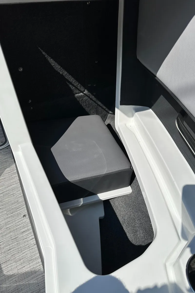 Slide: The Image of 2024 Cobalt CS22 boat interior storage compartment with cushioned seat. - 16