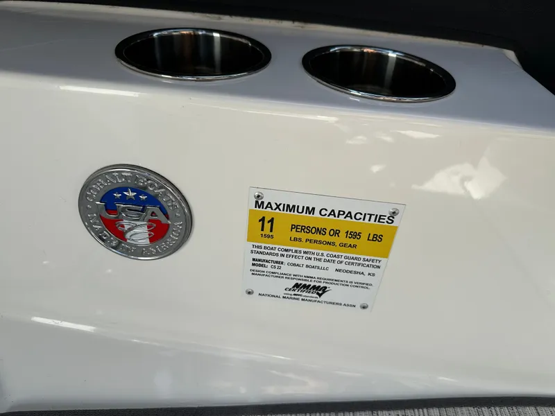 Slide: The Image of 2024 Cobalt CS22 boat capacity label and cup holders. - 18