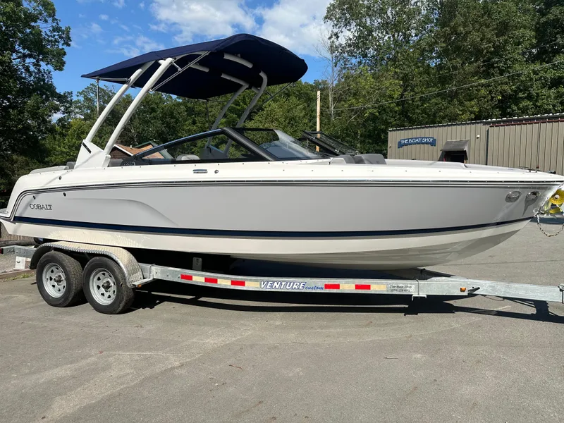 Slide: The Image of 2024 Cobalt CS22 boat on a trailer with a blue canopy. - 2