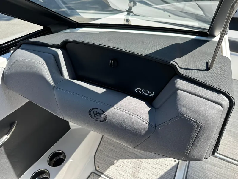 Slide: The Image of 2024 Cobalt CS22 boat dashboard with gray upholstery and cup holders. - 6